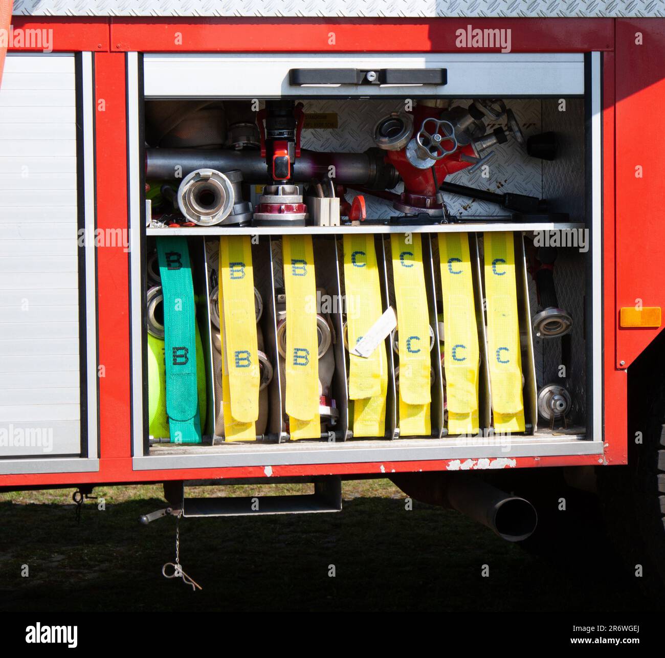Geräteraum eines Feuerwehrautos mit Schläuchen die Wasser pumpen Stock Photo