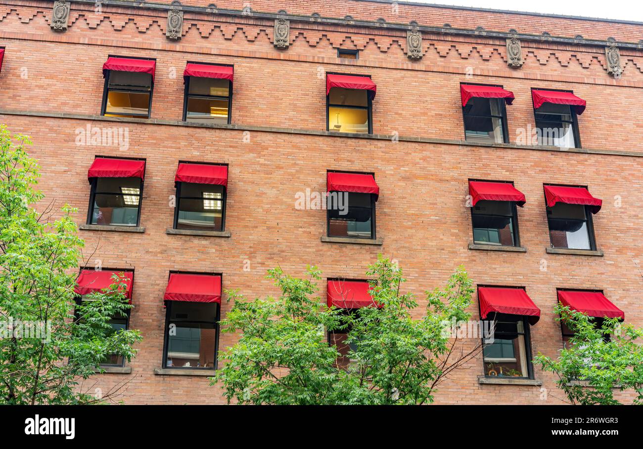 Pattern of windows with red shades in a brick building Stock Photo - Alamy