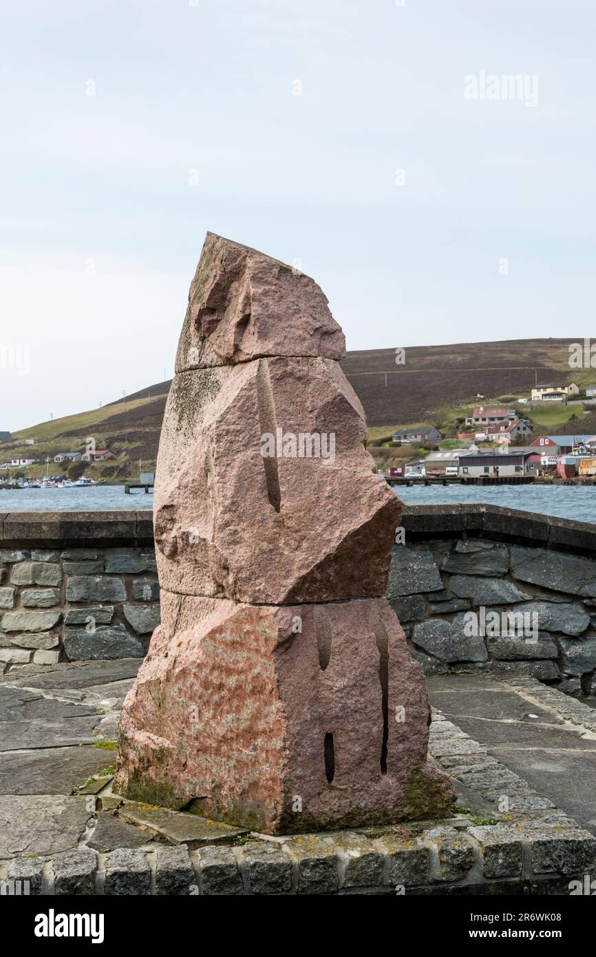 Head to the Wind is a sculpture by Fly Freeman in rose granite from Aberdeenshire. It stands on the waterfront of Scalloway on Shetland Mainland. Stock Photo