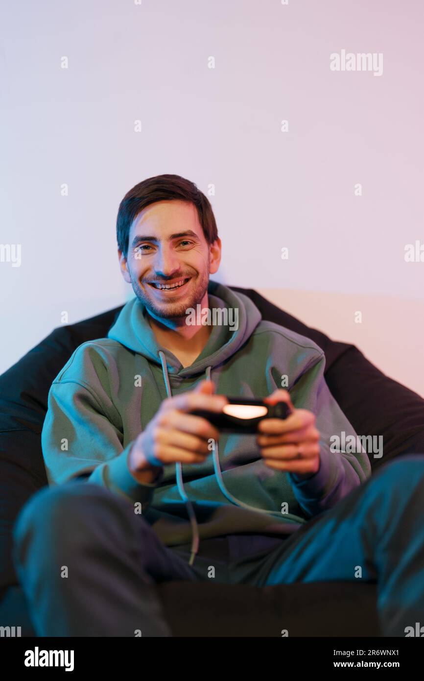 Cheerful male playing video game on console Stock Photo - Alamy