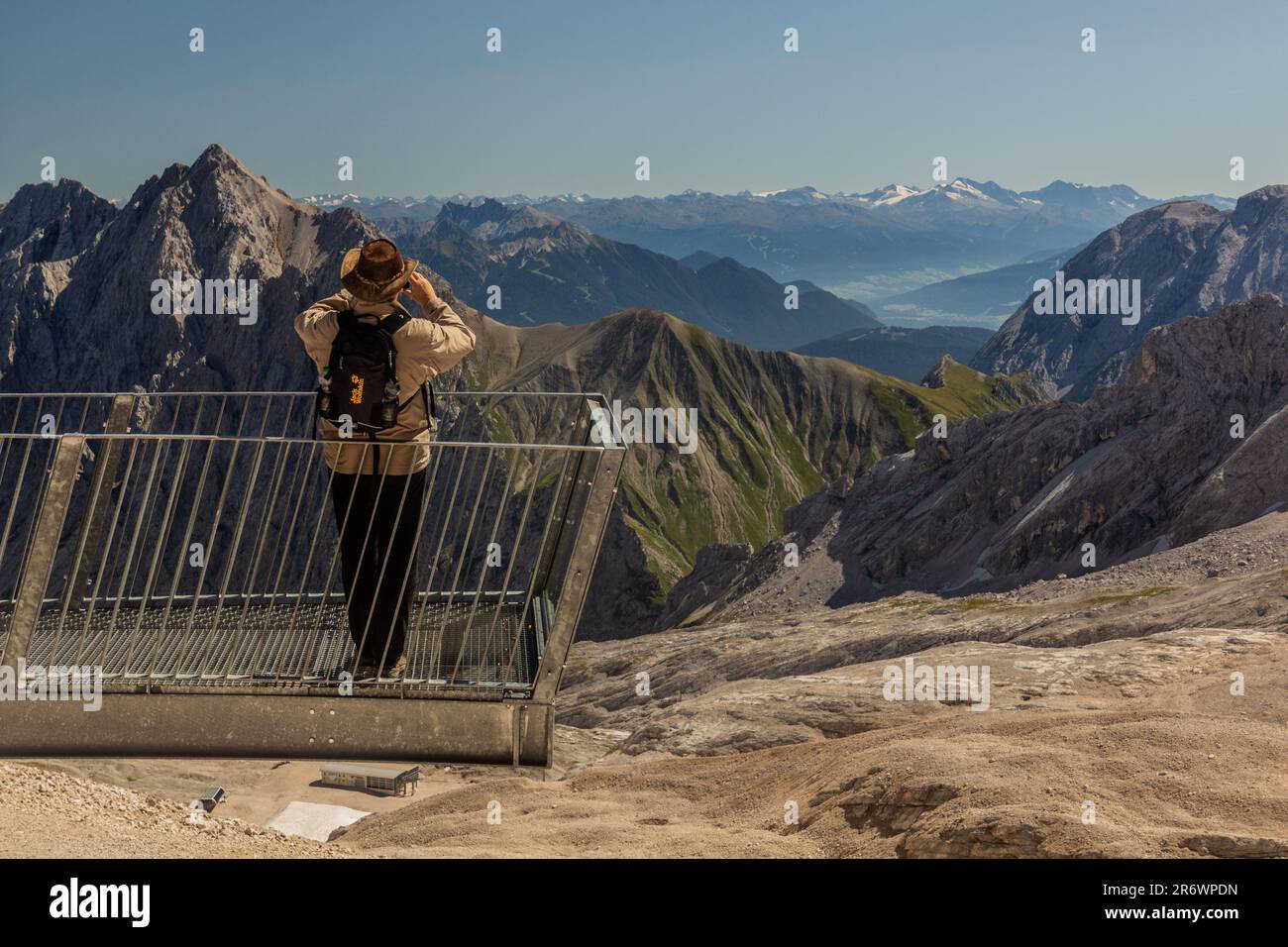 ZUGSPITZE, GERMANY - SEPTEMBER 4, 2019: Tourist enjoys a viewpoint at Zugspitzplatt plateau under Zugspitze peak, Germany Stock Photo