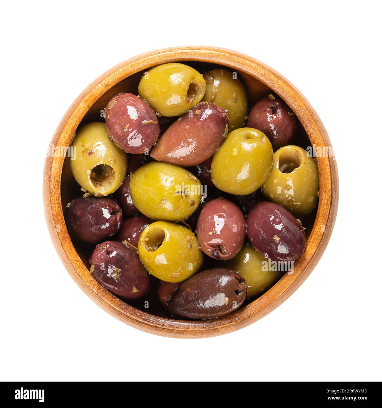 Pitted Kalamata and green olives, in a wooden bowl. Mix of organic Greek olives, green and black, with herbs, preserved in native olive oil. Stock Photo