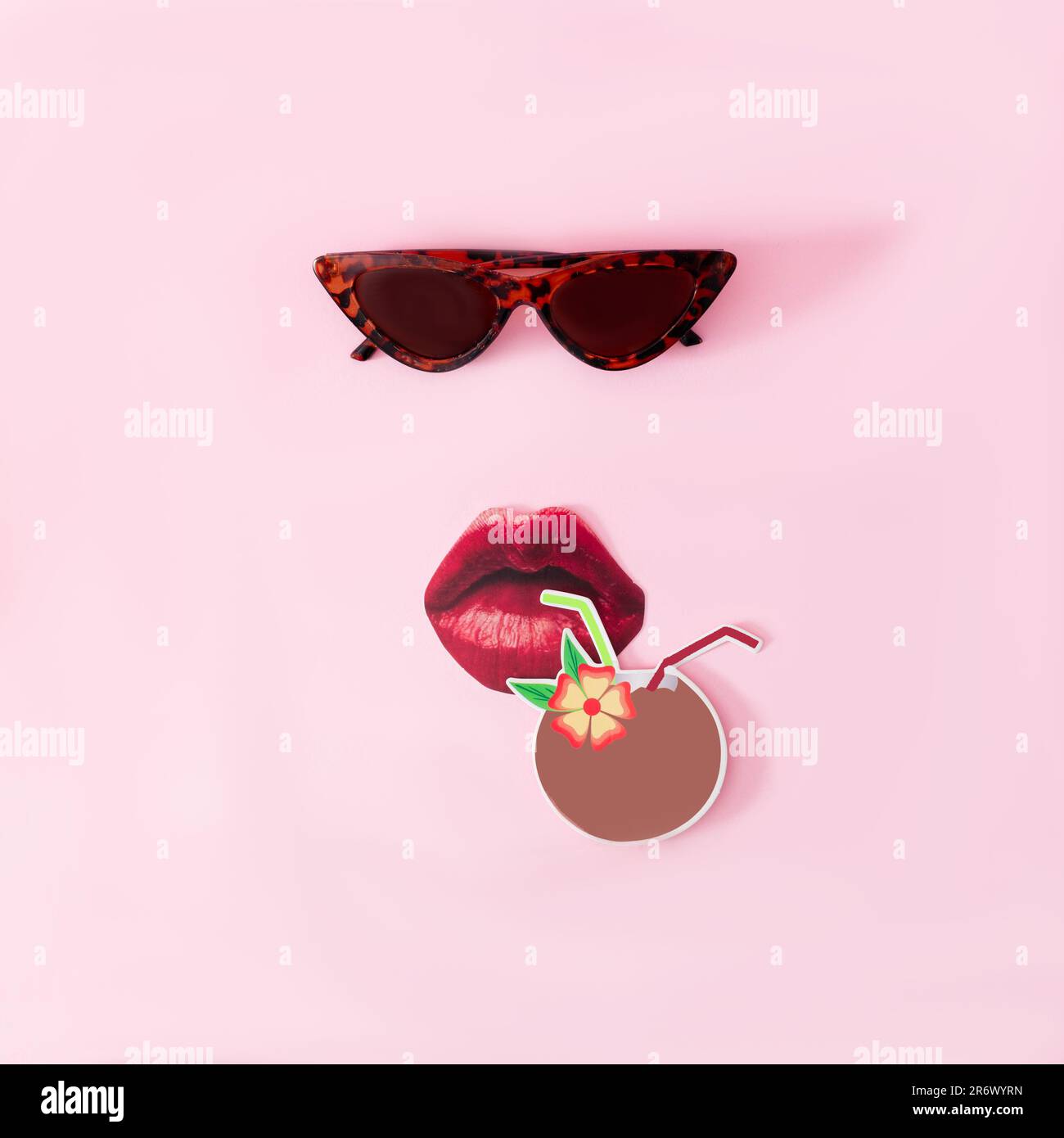 Cat eyes shaped sunglasses, red lips and a coconut with a straw on pink background. Minimal surreal concept for exotic summer holidays advertisement Stock Photo