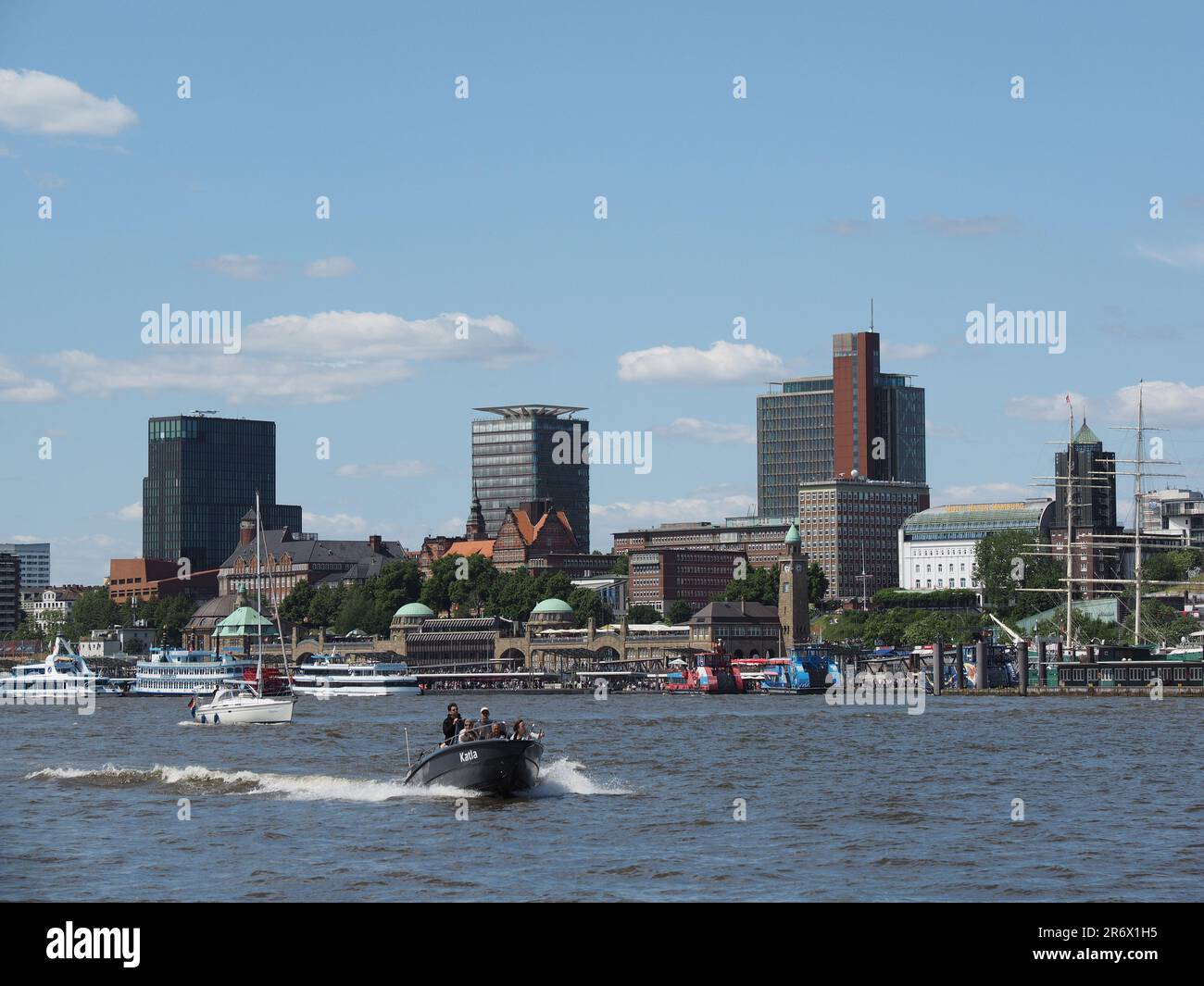 The city of Hamburg seen from the water of the river Elbe, with various small boats and people ejoying the sunny weather. Stock Photo
