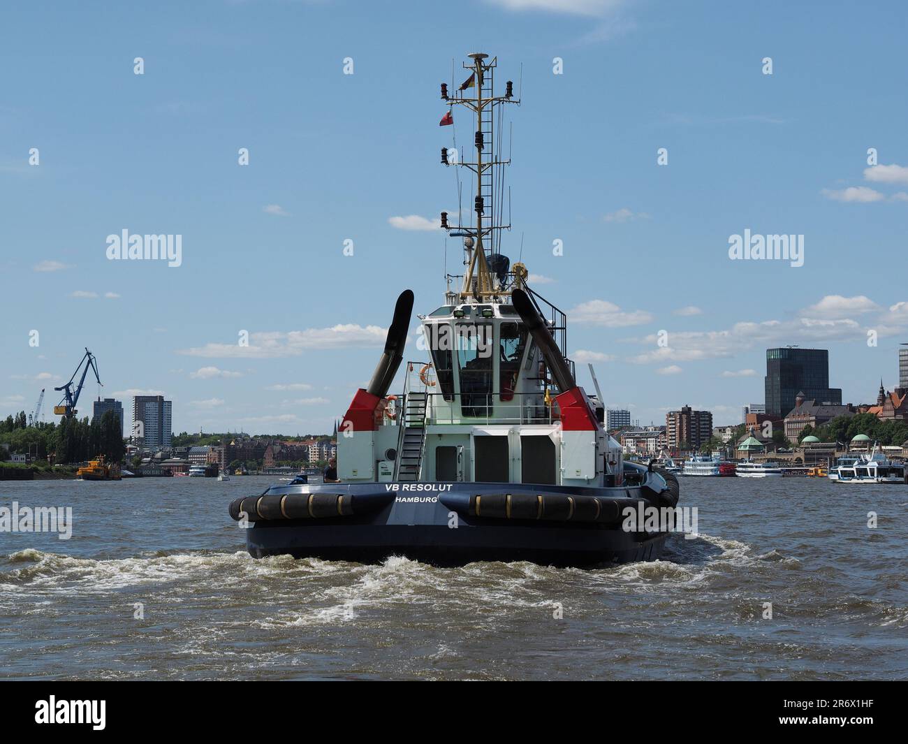 Tug boat VB Resolut in the port of Hamburg, Germany, with the city skyline in the background Stock Photo