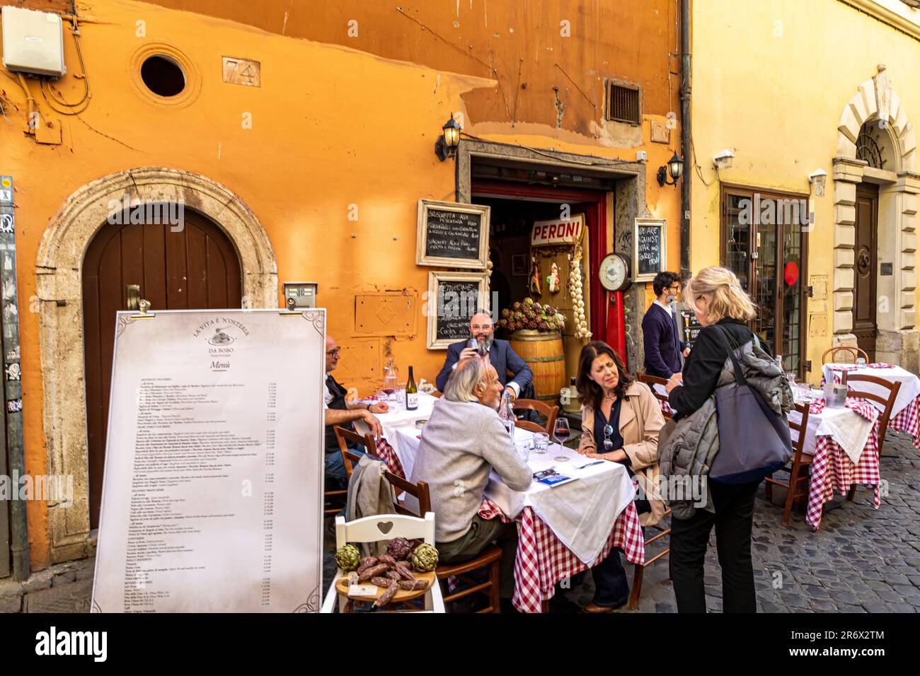 People sitting outside dining atLa vita è’ n’osteria , a small restaurant  in Trastevere, Rome, Italy Stock Photo