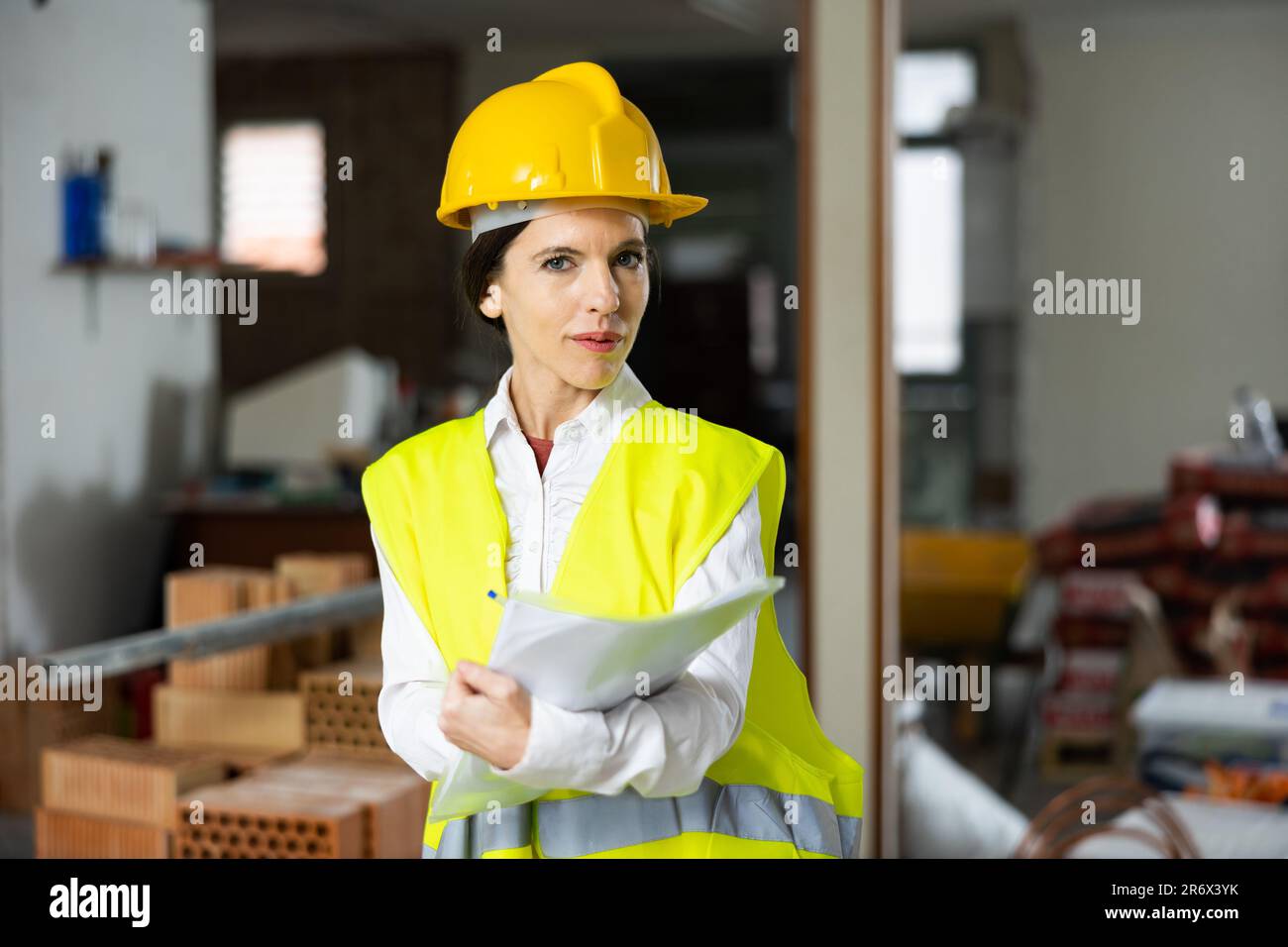 Female supervisor taking notes while inspecting construction site indoors Stock Photo