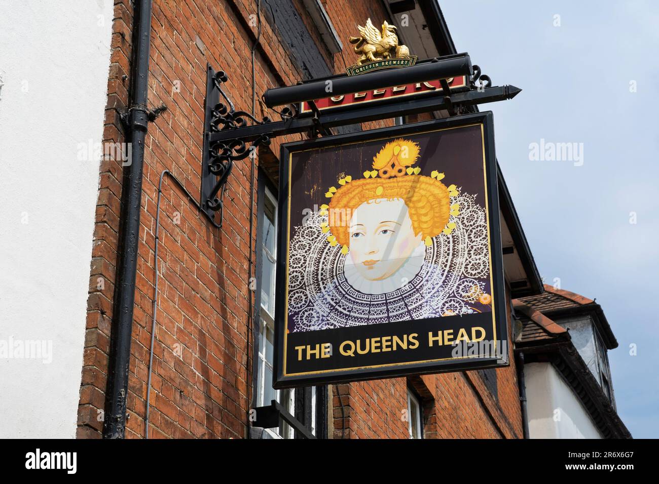 The Queen's Head - a traditional red brick pub on the Borough in Farnham, with a hanging sign outside with a likeness of Queen Elizabeth First. UK Stock Photo