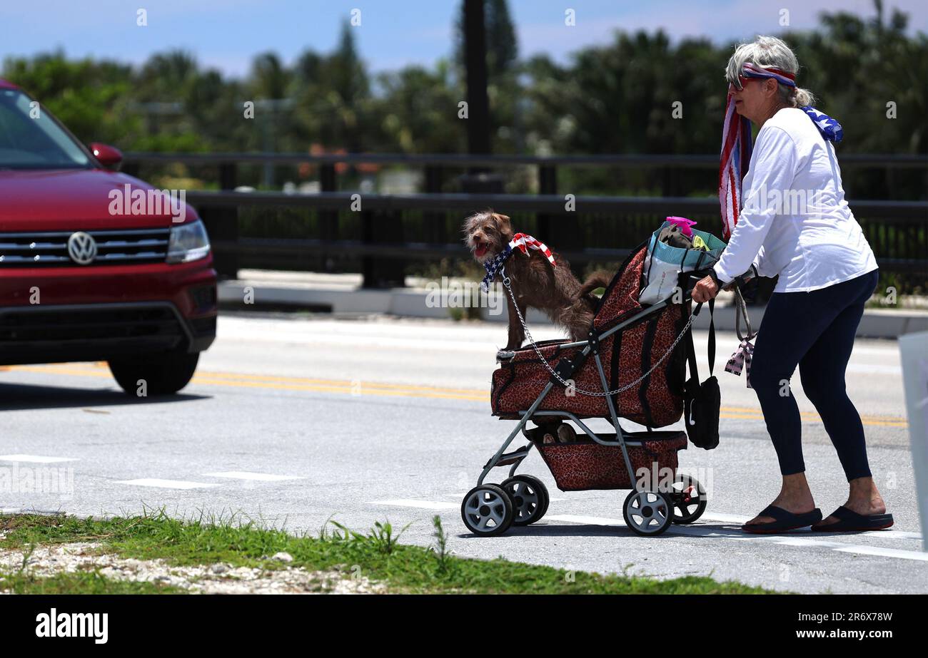 Palm Beach, United States. 11th June, 2023. A supporter of former President Donald Trump Paula walks across the road with her dogs Benji and Shila to a rally prior to Trump's appearance in Miami Federal Court displaying signs and flags across from Mar-a-Lago in Palm Beach, Florida, on Sunday, June 11, 2023. Trump will be in Federal court on Tuesday, June 13, 2023 to respond to a 37 count indictment accusing him of mishandling sensitive government secrets. Photo by Gary I Rothstein/UPI Credit: UPI/Alamy Live News Stock Photo