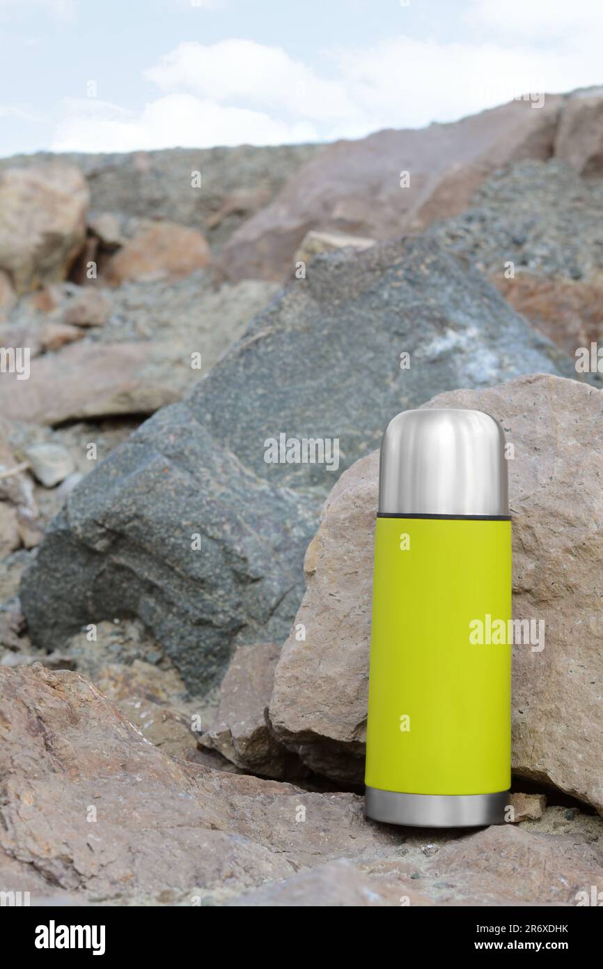 Aluminium Thermos with Hot Drink on Rock Stone Outdoors. Space for