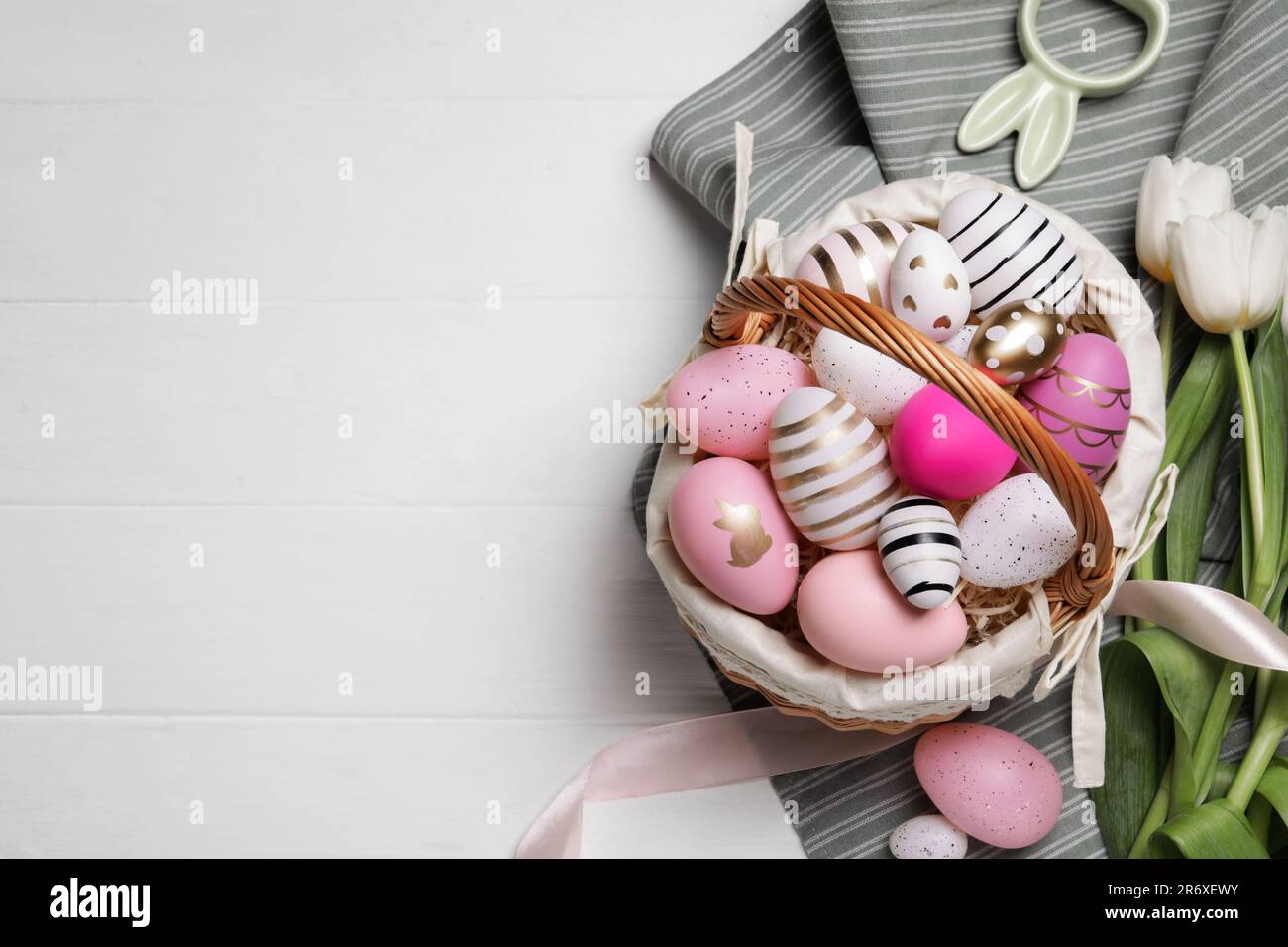 Flat lay composition with Easter eggs in basket and tulips on white ...