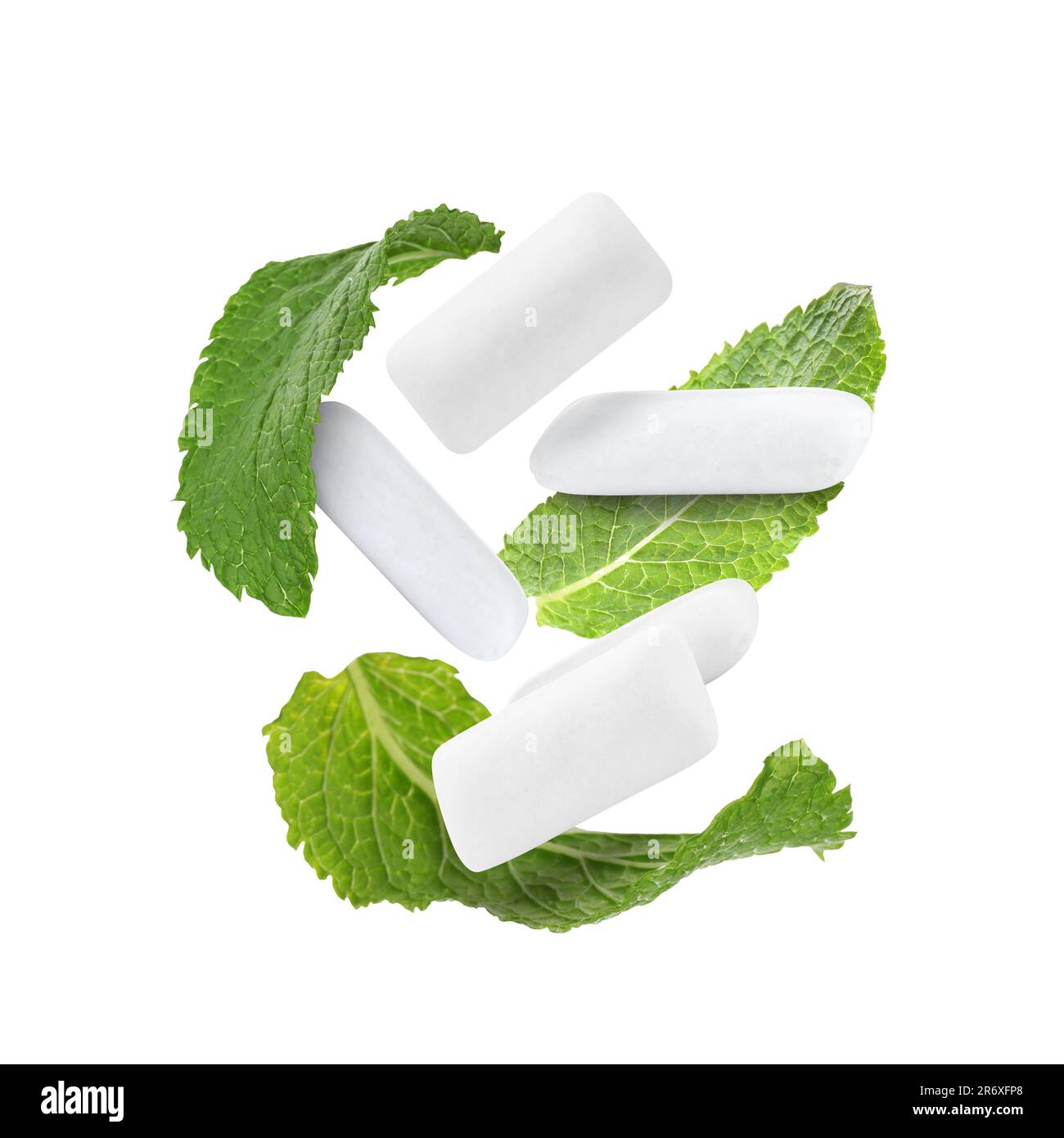 Fresh mint leaves and chewing gum pads falling on white background