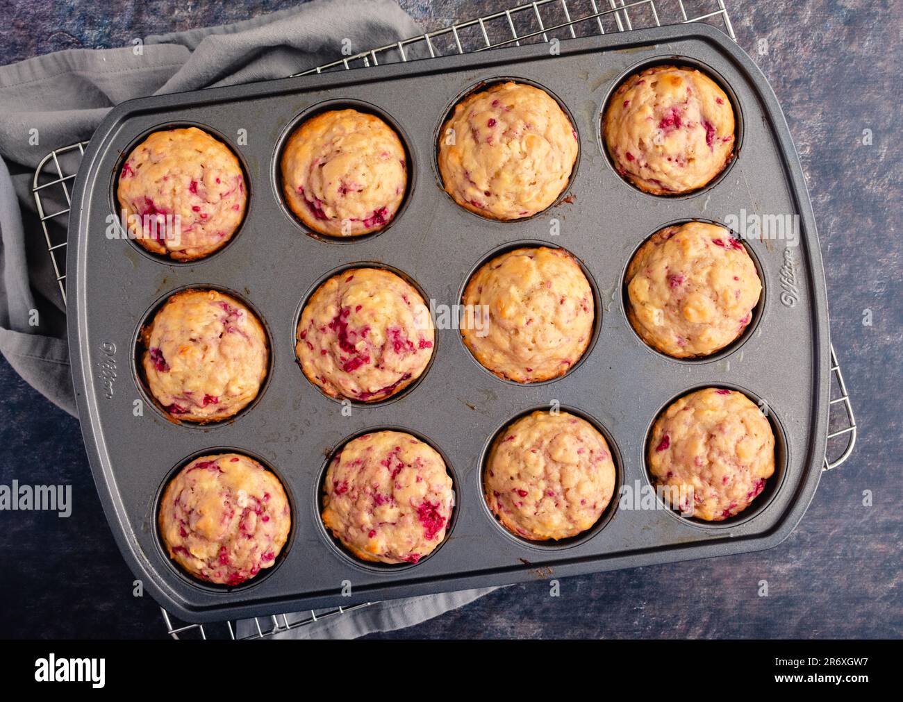 Freshly Baked Raspberry Muffins in a Nonstick Muffin Pan: Breakfast or dessert muffins made with fruit viewed from directly above in muffin tin Stock Photo