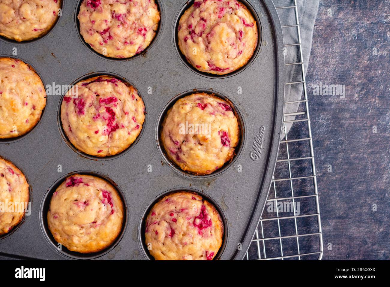 Freshly Baked Raspberry Muffins in a Nonstick Muffin Pan: Breakfast or dessert muffins made with fruit viewed from directly above in muffin tin Stock Photo