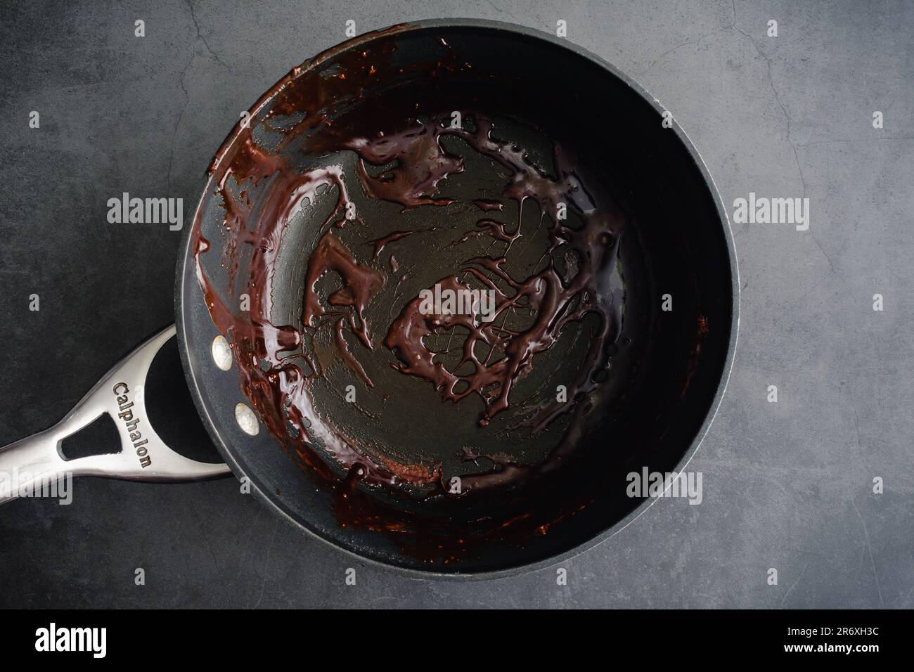 Empty used pot on a dark background viewed from directly above Stock Photo