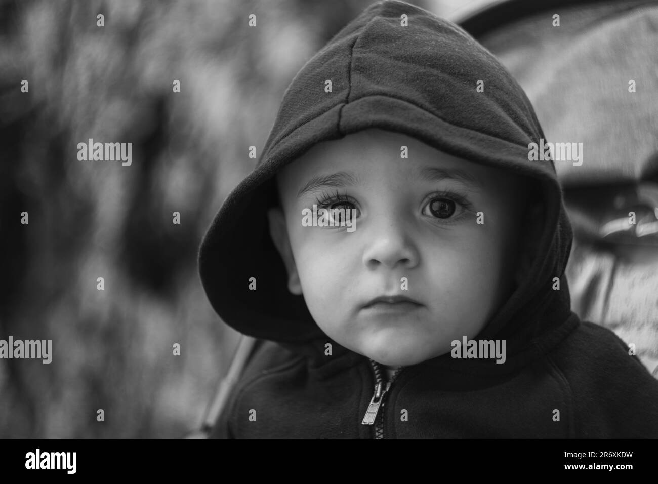 black and white portrait of a toddler in a hooded jumper Stock Photo