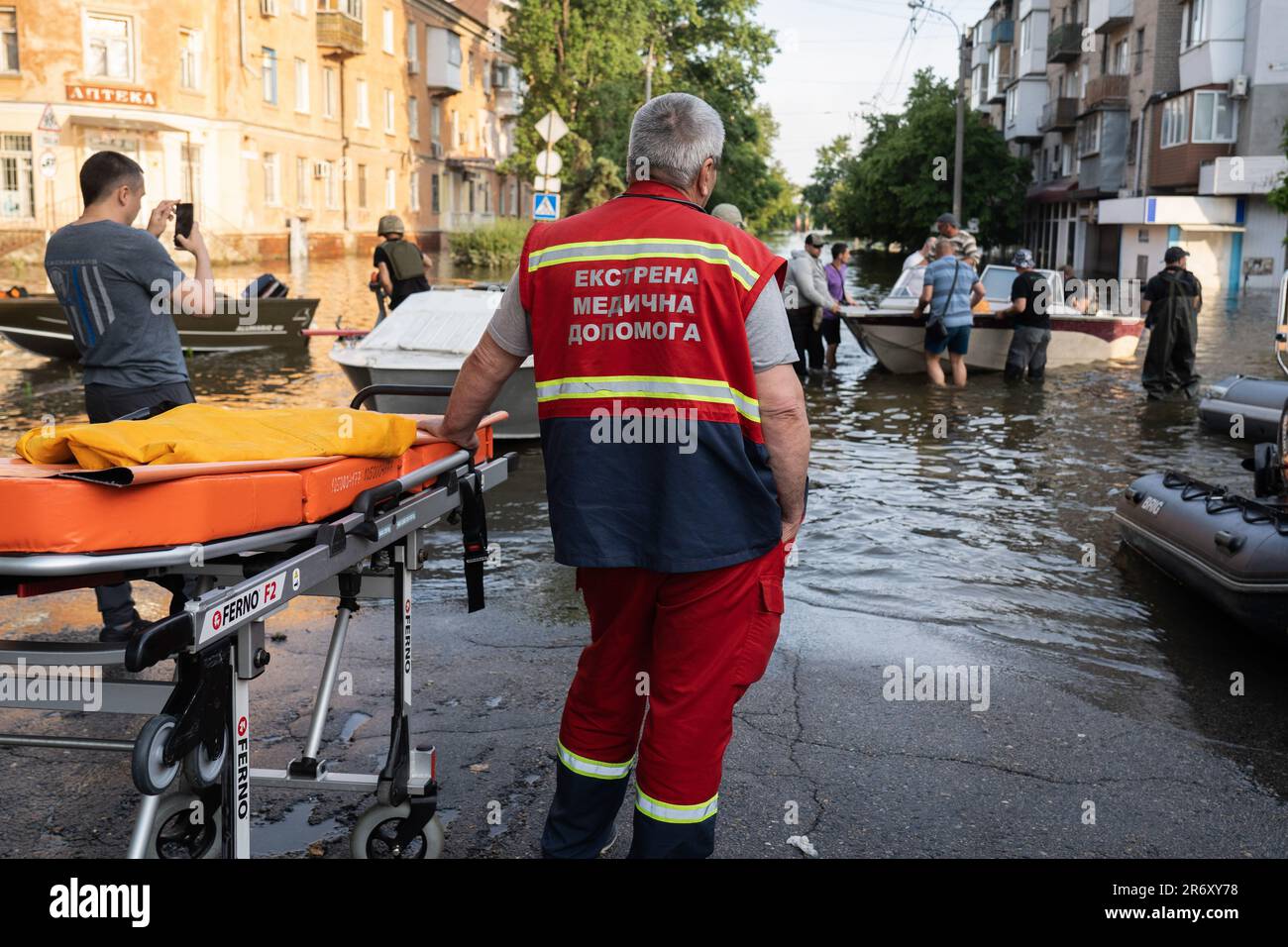 June 9, 2023, Kherson, Ukraine: A paramedic is seen waiting with a medical bed at the bank of the river in Kherson City. Kherson civilians have been evacuated as flooding continues to affect some areas in the city. Some evacuees are coming from left bank of Dnipro River, the occupied territory and reunited to their family first time since liberation in last November. As the water level recedes, evacuation is still underway despite willingness to leave has dropped. The collapse of Nova Kakhovka dam in southern Ukraine in June 6 has forced more than 1,400 people to flee their homes. Ukrainian an Stock Photo
