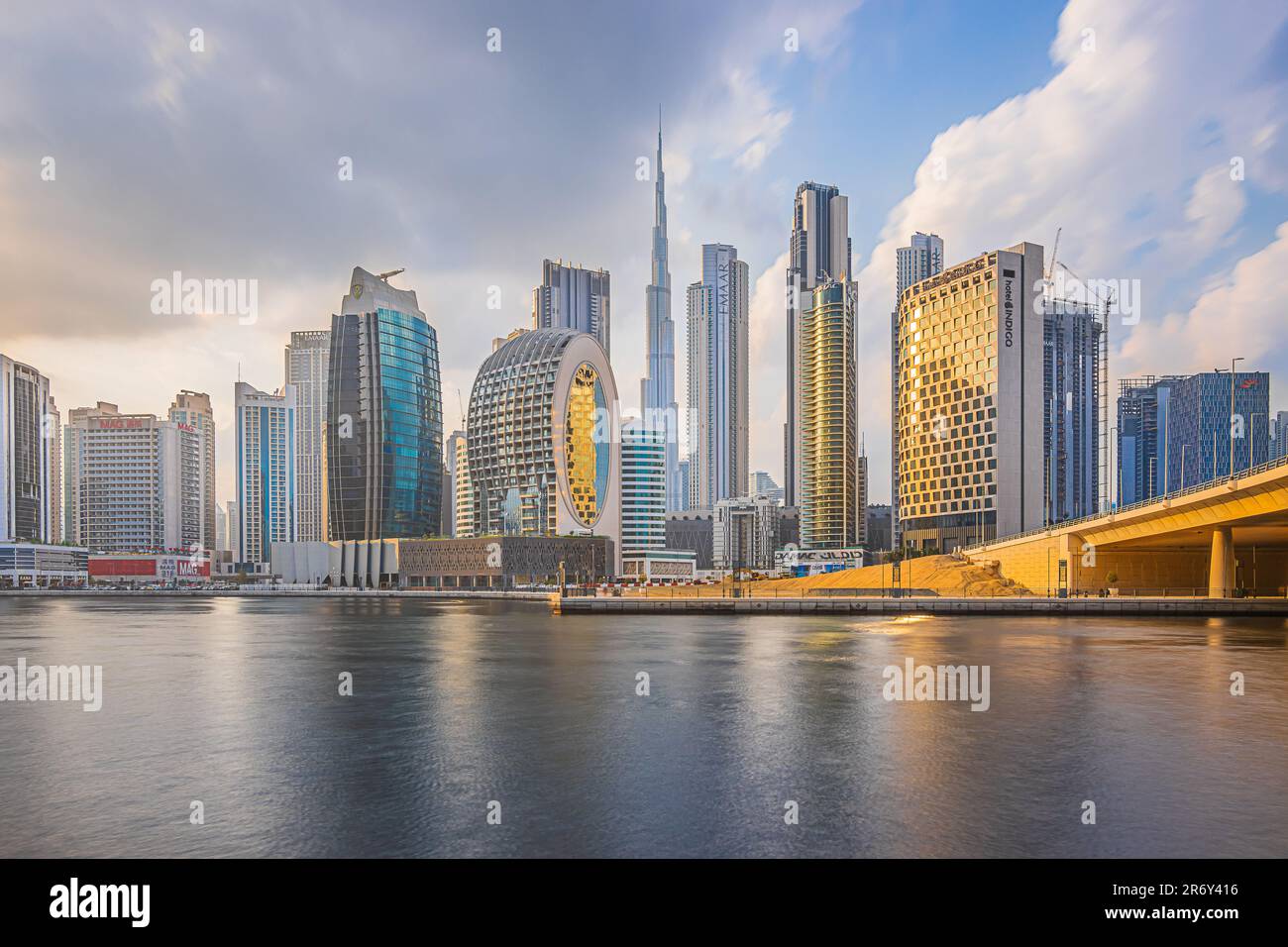 Sunset in Dubai. Skyscrapers and Burj Khalifa in the evening. Skyline with cloudy sky and waterfront in Dubai port. Houses with glass front Stock Photo