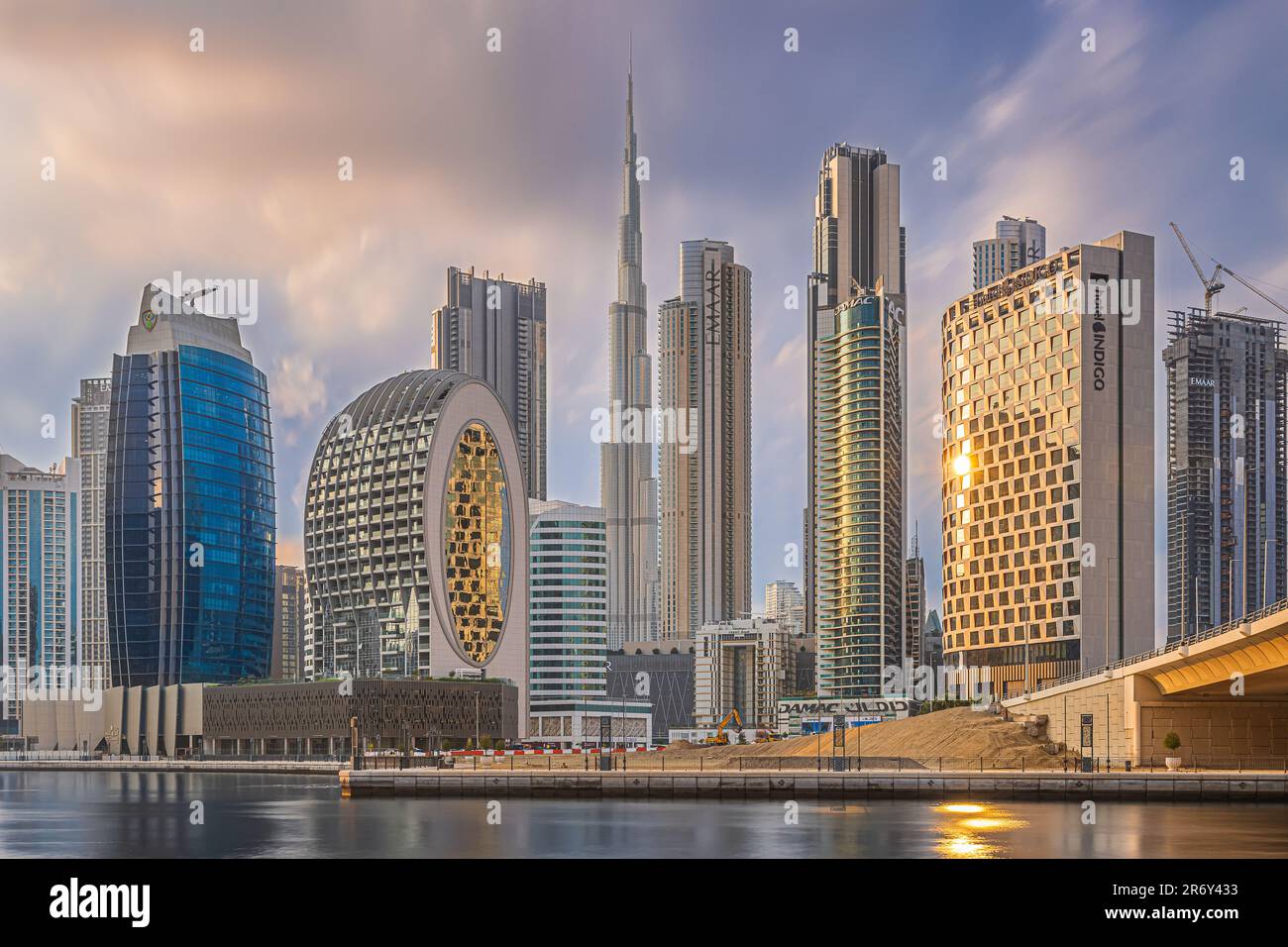 Sunset in Dubai. City center with commercial buildings and skyscrapers around Burj Khalifa. Skyline in the evening at sunset with a cloudy sky. Stock Photo