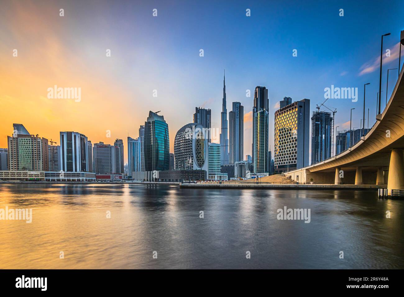 Skyline of Dubai in the evening at sunset. High-rise buildings in the business and financial center of the Arab city in the Emirates. Skyscraper Stock Photo