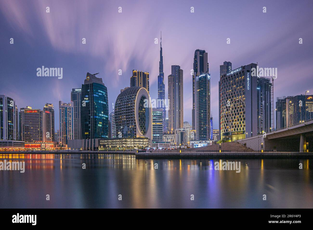 Blue Hour in Dubai. Long exposure in the evening after sunset. View of downtown skyline in United Arab Emirates. Illuminated commercial building Stock Photo