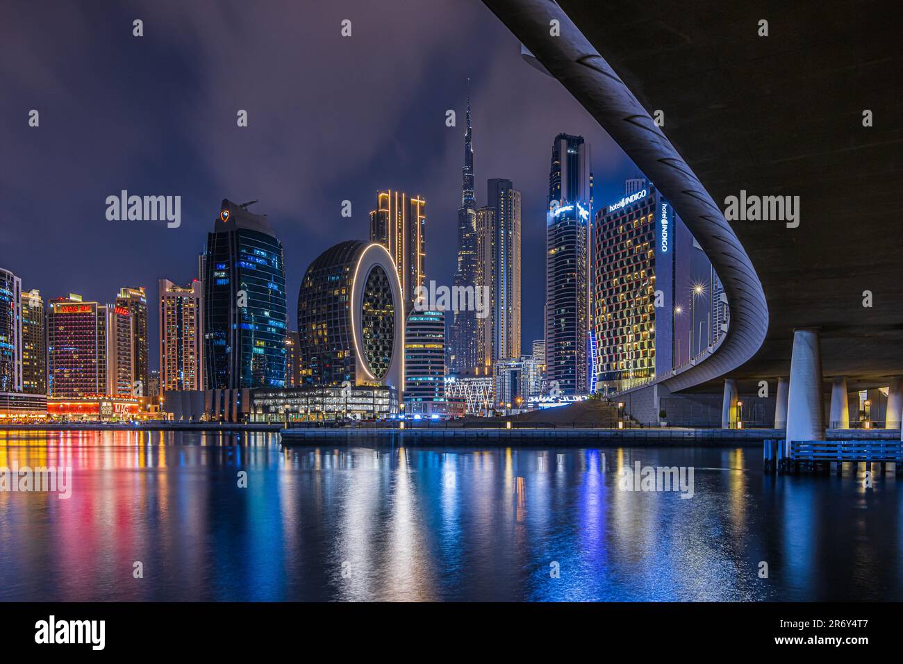 View of the Dubai skyline at night. Financial center of the city in United Arab Emirates. Skyscrapers illuminated at the blue hour with curved course Stock Photo