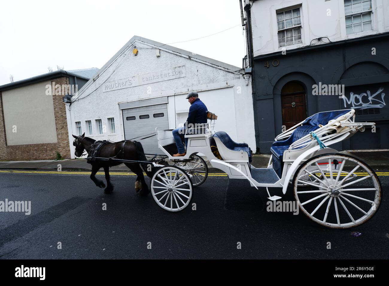 A coachman driving his horse drawn carriage on Watling street in Dublin