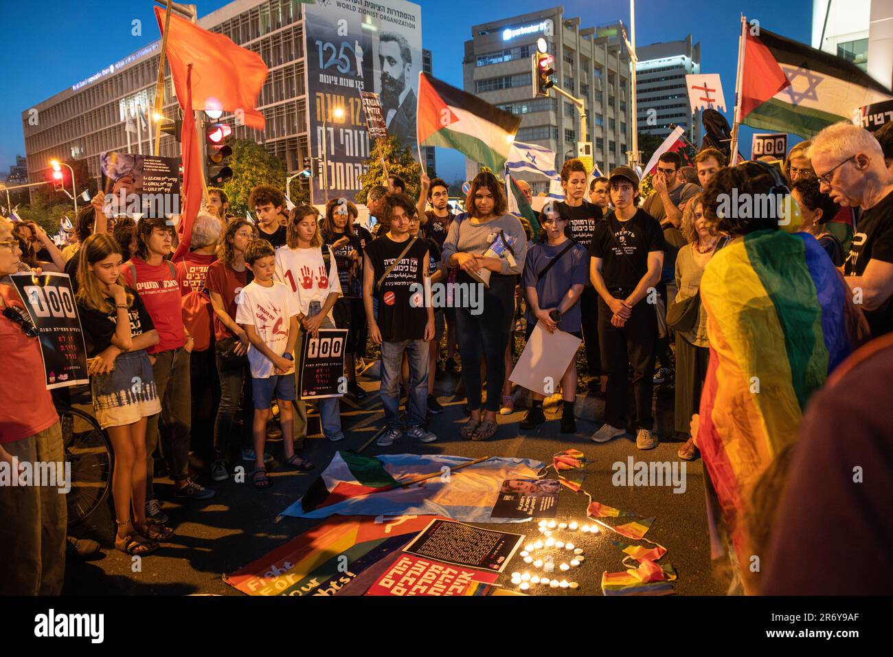 Tel Aviv, Israel. 10th June, 2023. Israeli peace and pride activists wave Israeli and Palestinian flags next to candles lit in memory of 101 Israeli Arab victims of increasing crime and violence in Israeli Arab towns and villages during a demonstration against the judicial reform. Credit: SOPA Images Limited/Alamy Live News Stock Photo