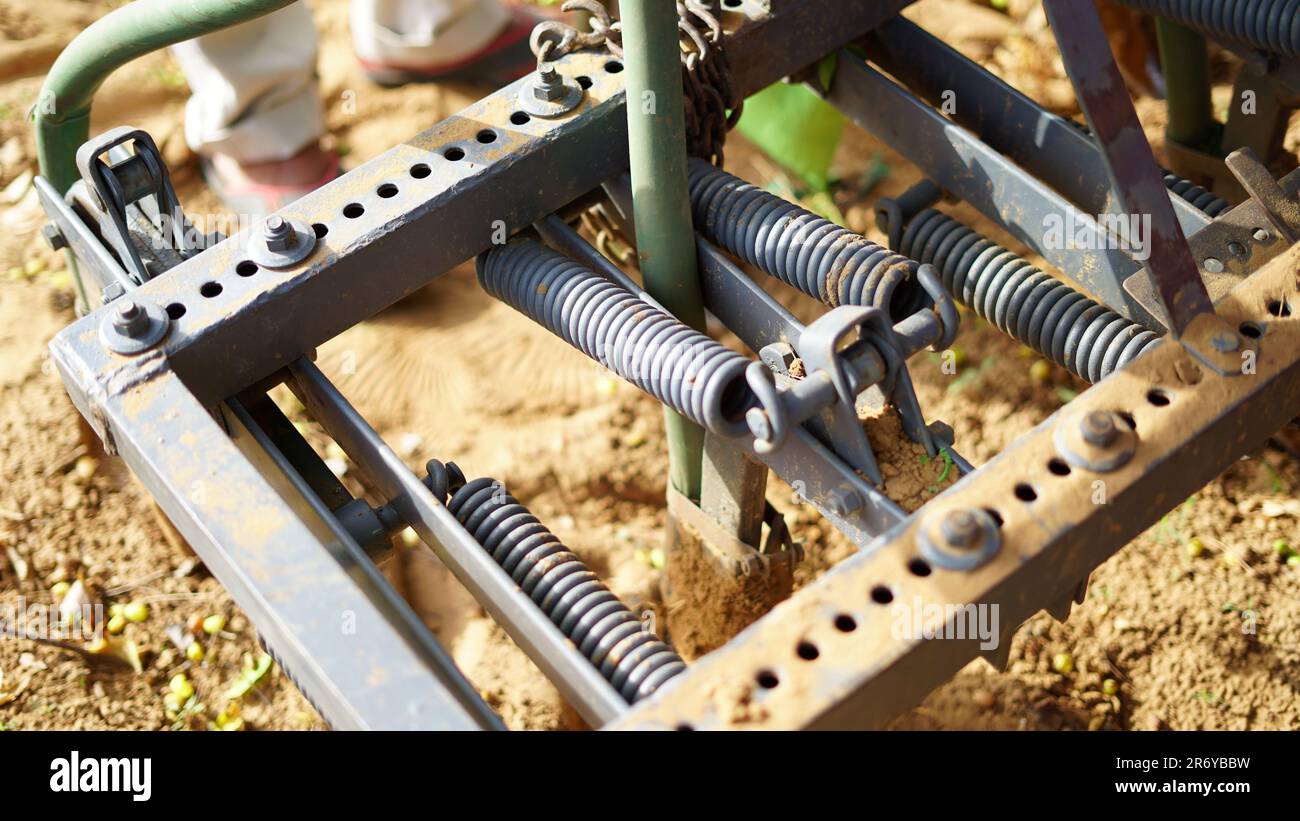 Spring mechanism on a old agricultural cultivator machine. Spring shock absorbers cultivator. Stock Photo