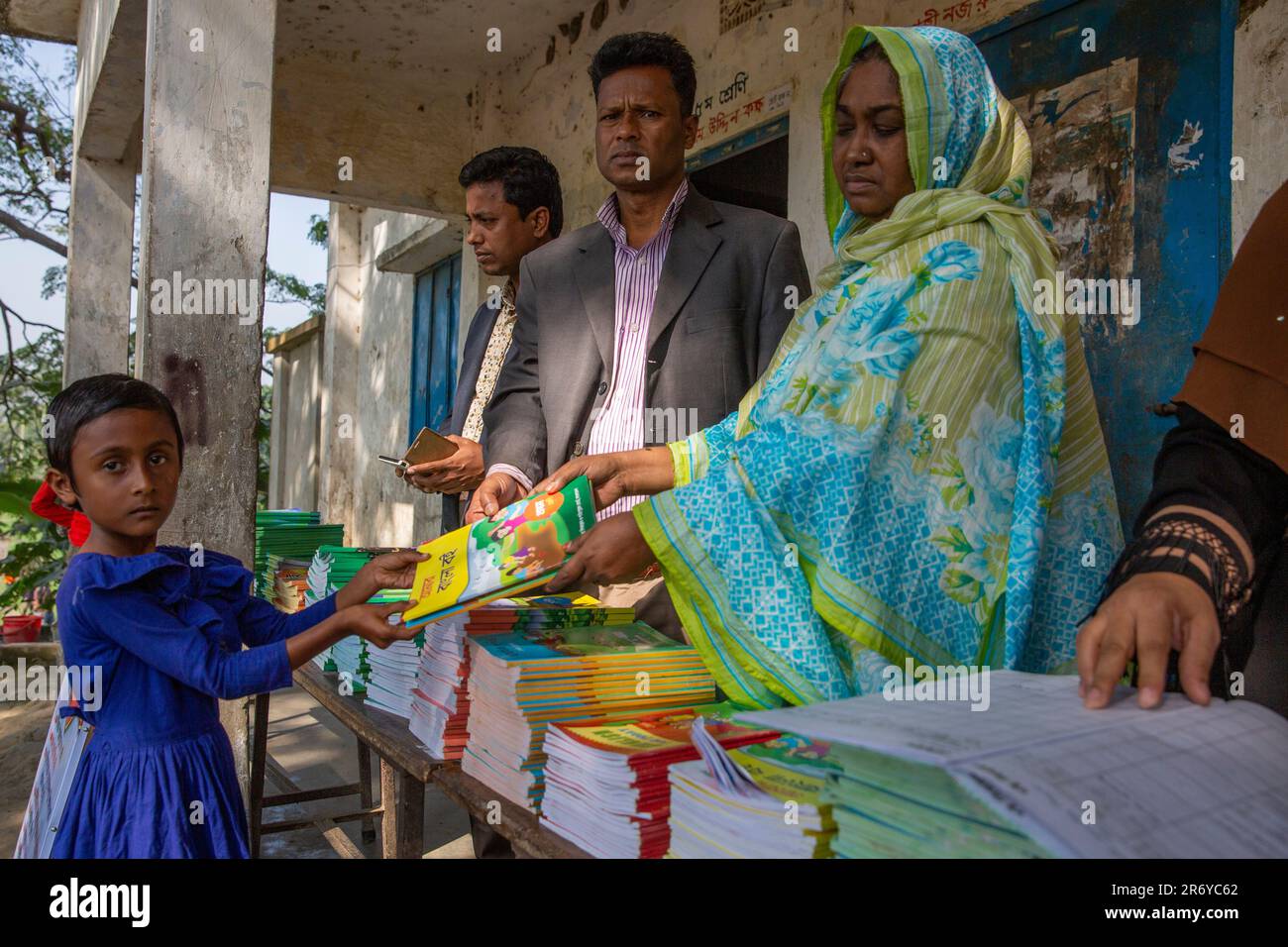 A student receives new textbook for the new academic year from teachers
