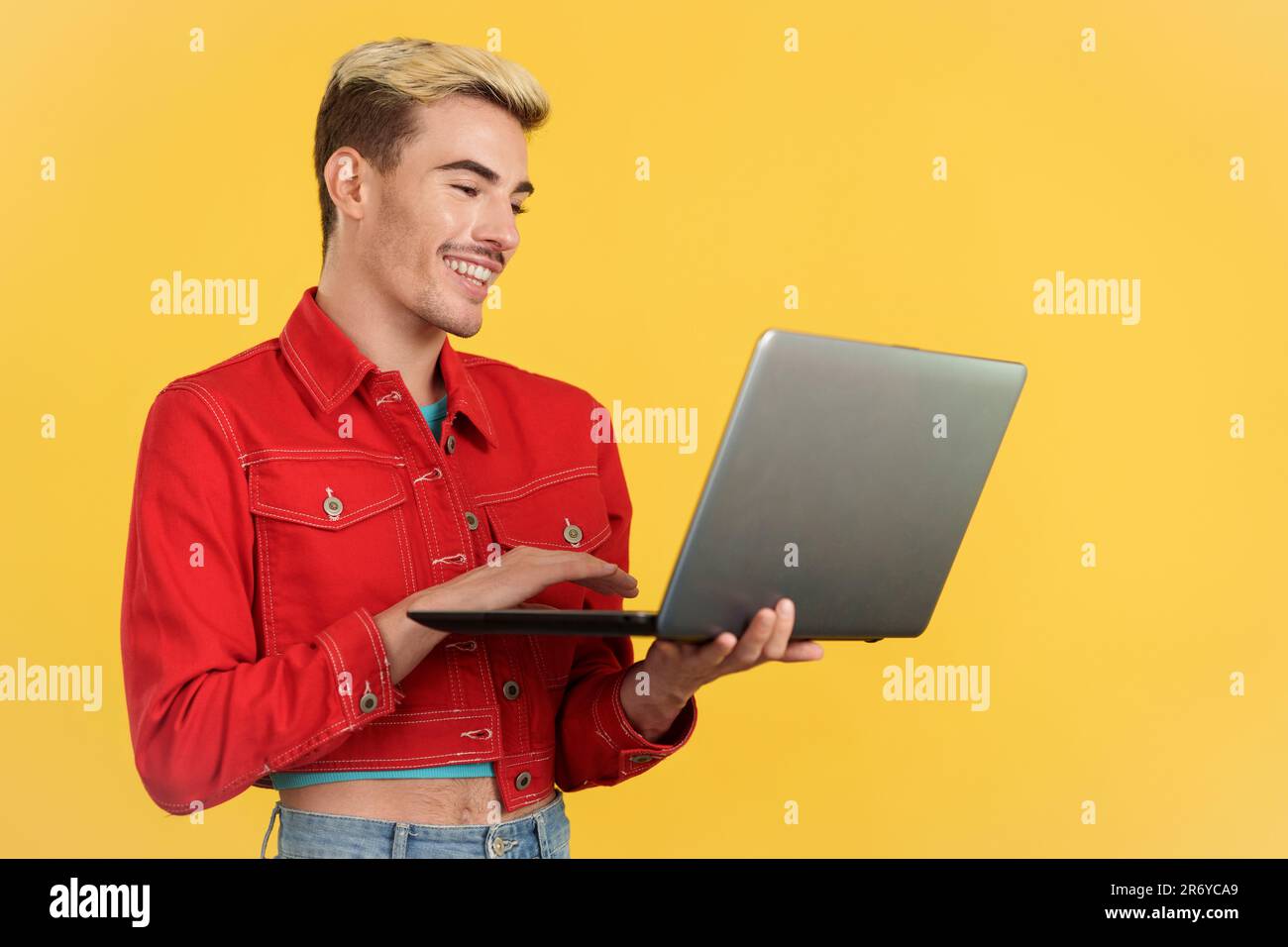 Stylish gay man smiling while using a laptop Stock Photo