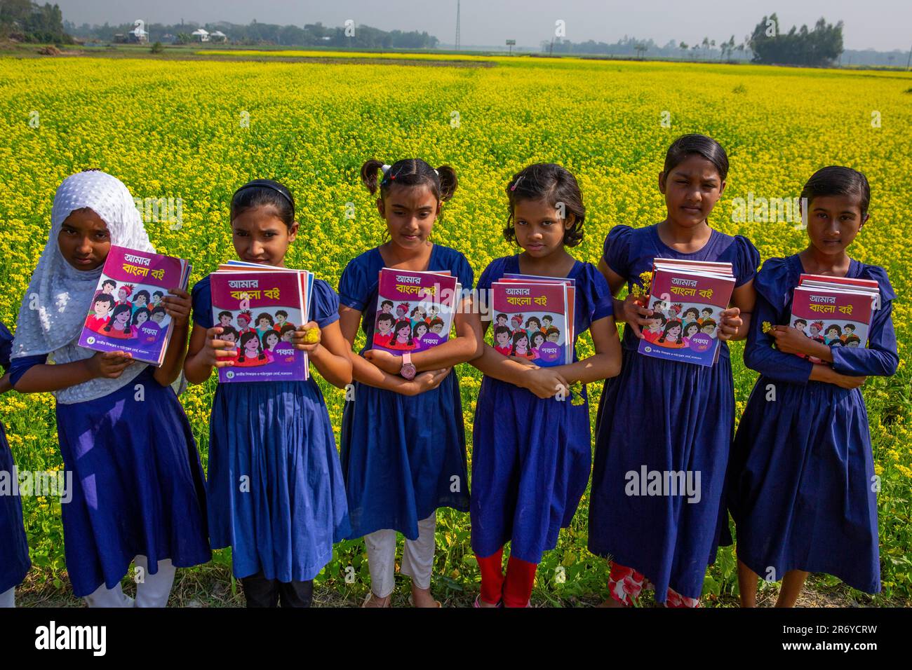 Bangladeshi primary school students hold new textbooks after receiving