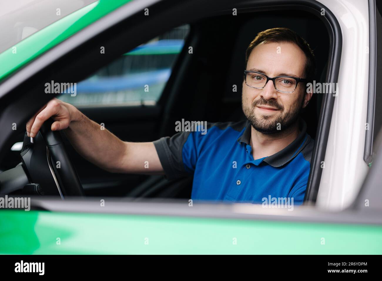 Photo of mechanic look into camera through an open car window. Man in ...