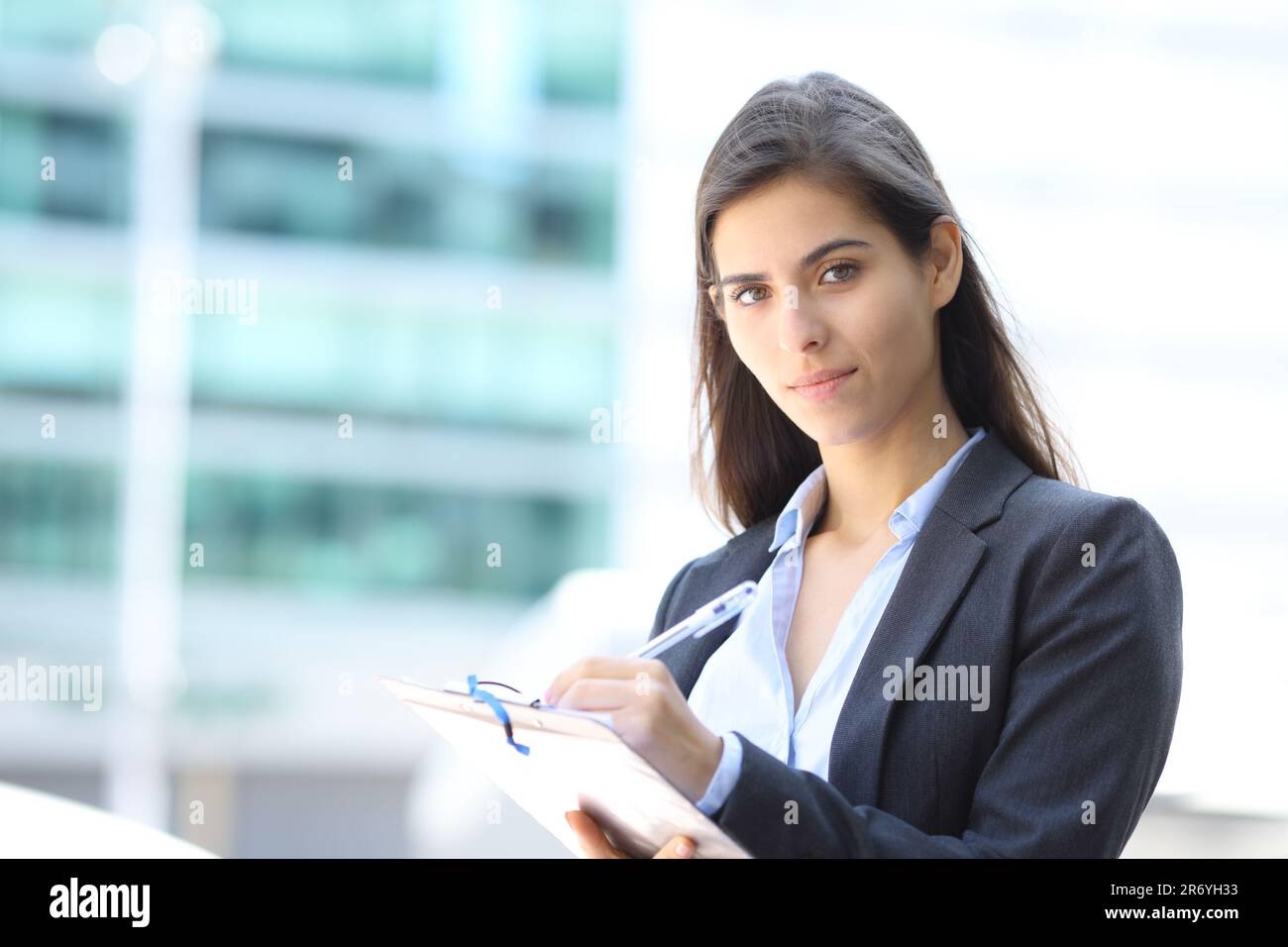 Pollster filling questionnaire in the street looking at you Stock Photo