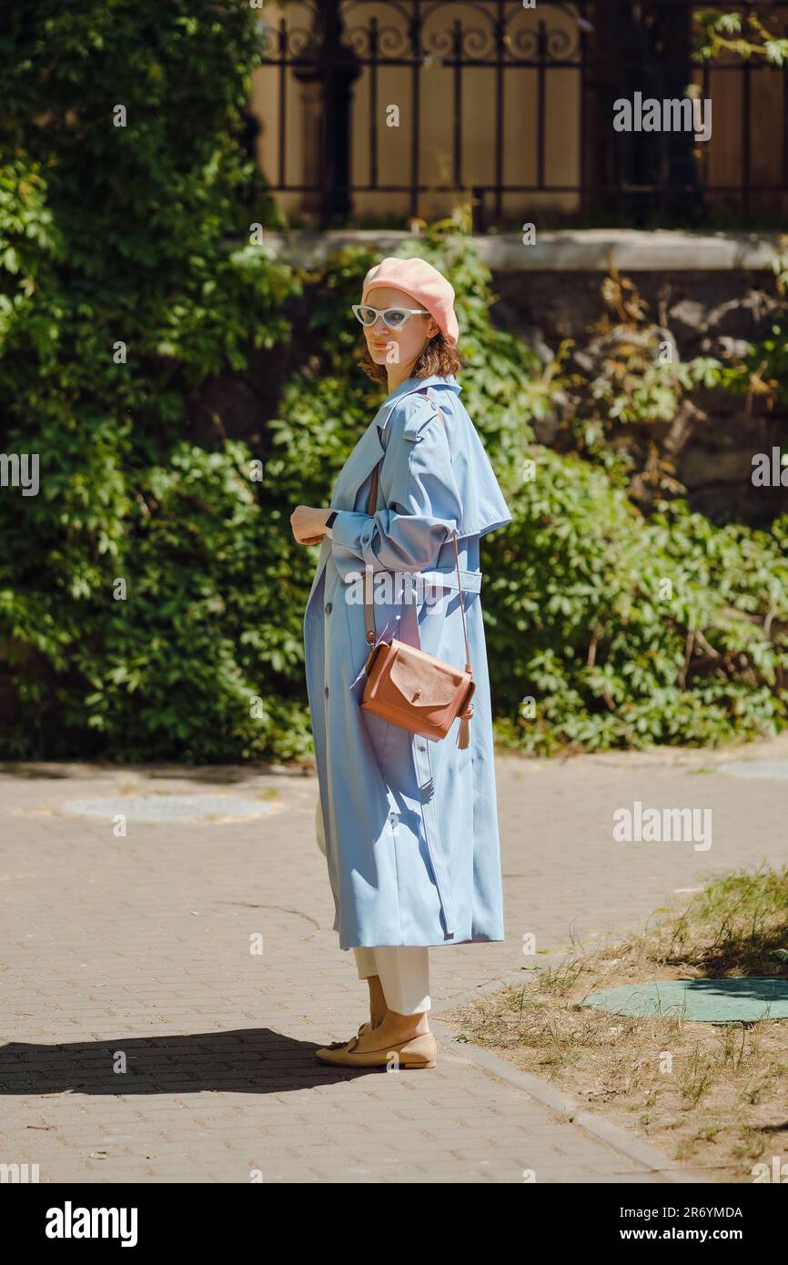 Woman in blue cloak and coral beret stopped and turned back Stock Photo ...