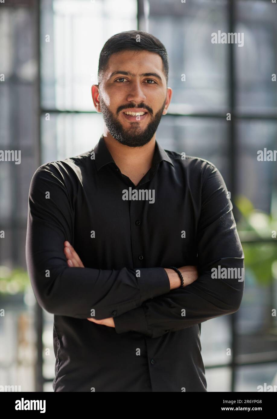 young businessman smiling in the office with his arms crossed Stock ...