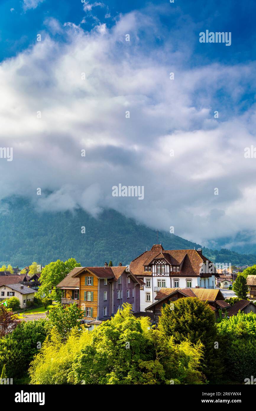 View of traditional style Swiss houses and mountains in Matten bei Interlaken, Switzerland Stock Photo