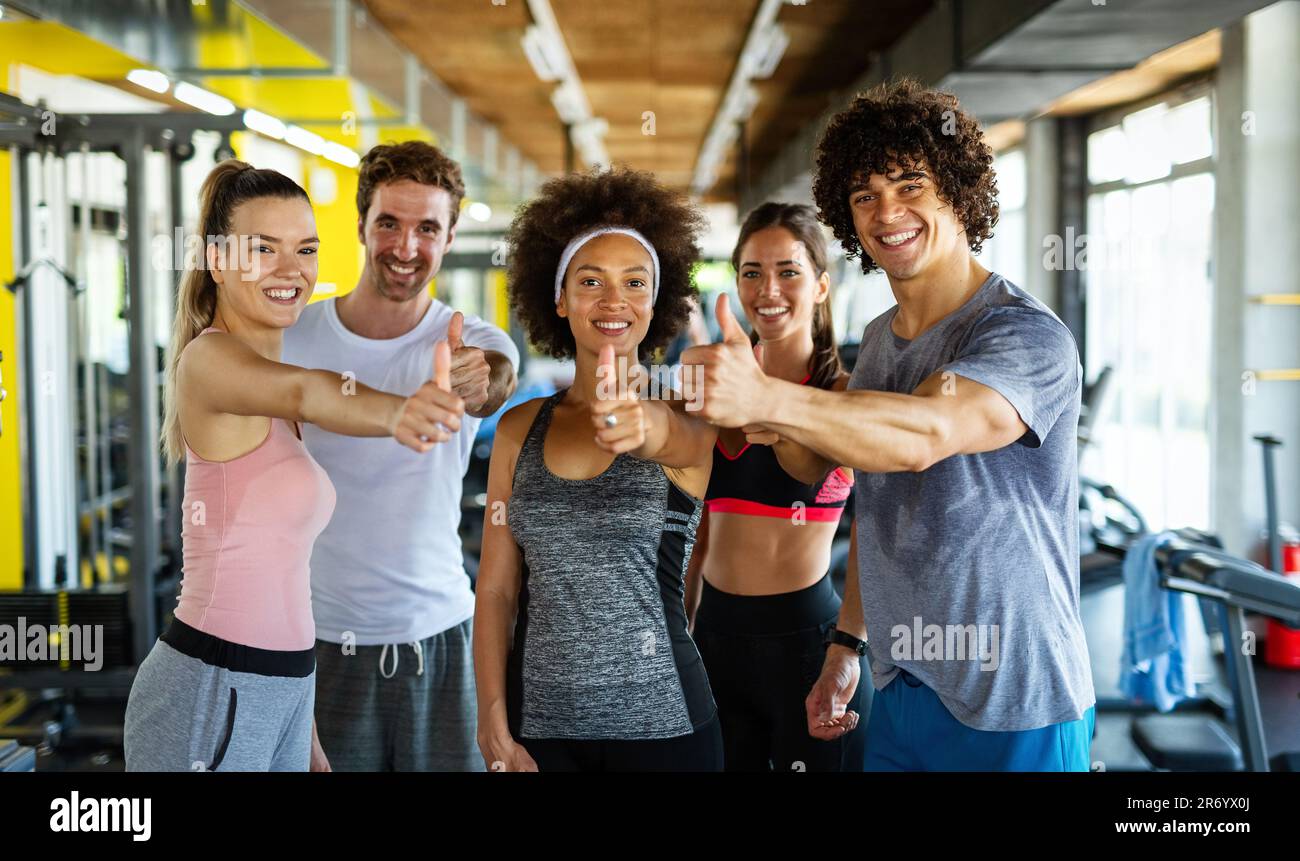 Group of young fit people, friends doing exercises in gym to stay ...