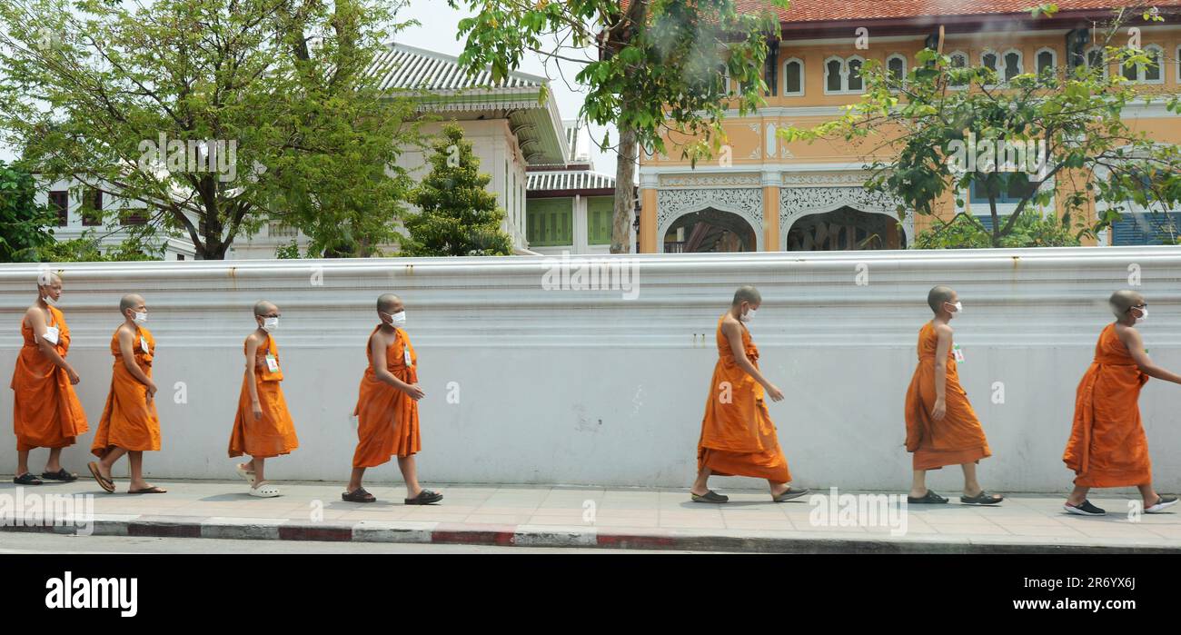 Buddhist monks collecting alms near the Wat Bowonniwetwiharn Ratchaworawiharn in Banglamphu, Bangkok, Thailand. Stock Photo