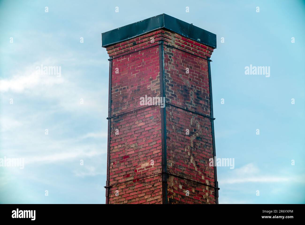 A traditional brick chimney with a red tiles against a blue sky Stock ...