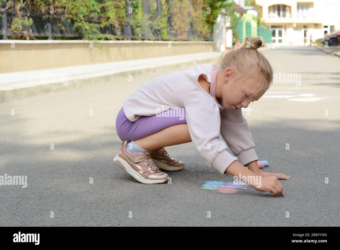 Little child drawing butterfly with chalk on asphalt Stock Photo - Alamy