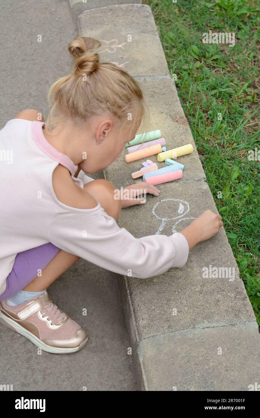 Little child drawing balloons with chalk on asphalt Stock Photo - Alamy