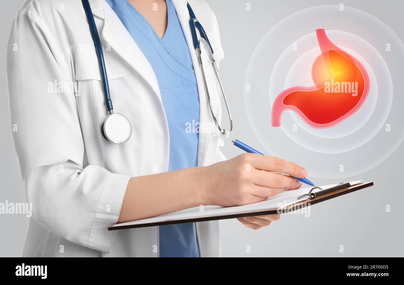 Treatment of heartburn and other gastrointestinal diseases. Doctor with clipboard on light background, closeup. Stomach illustration Stock Photo