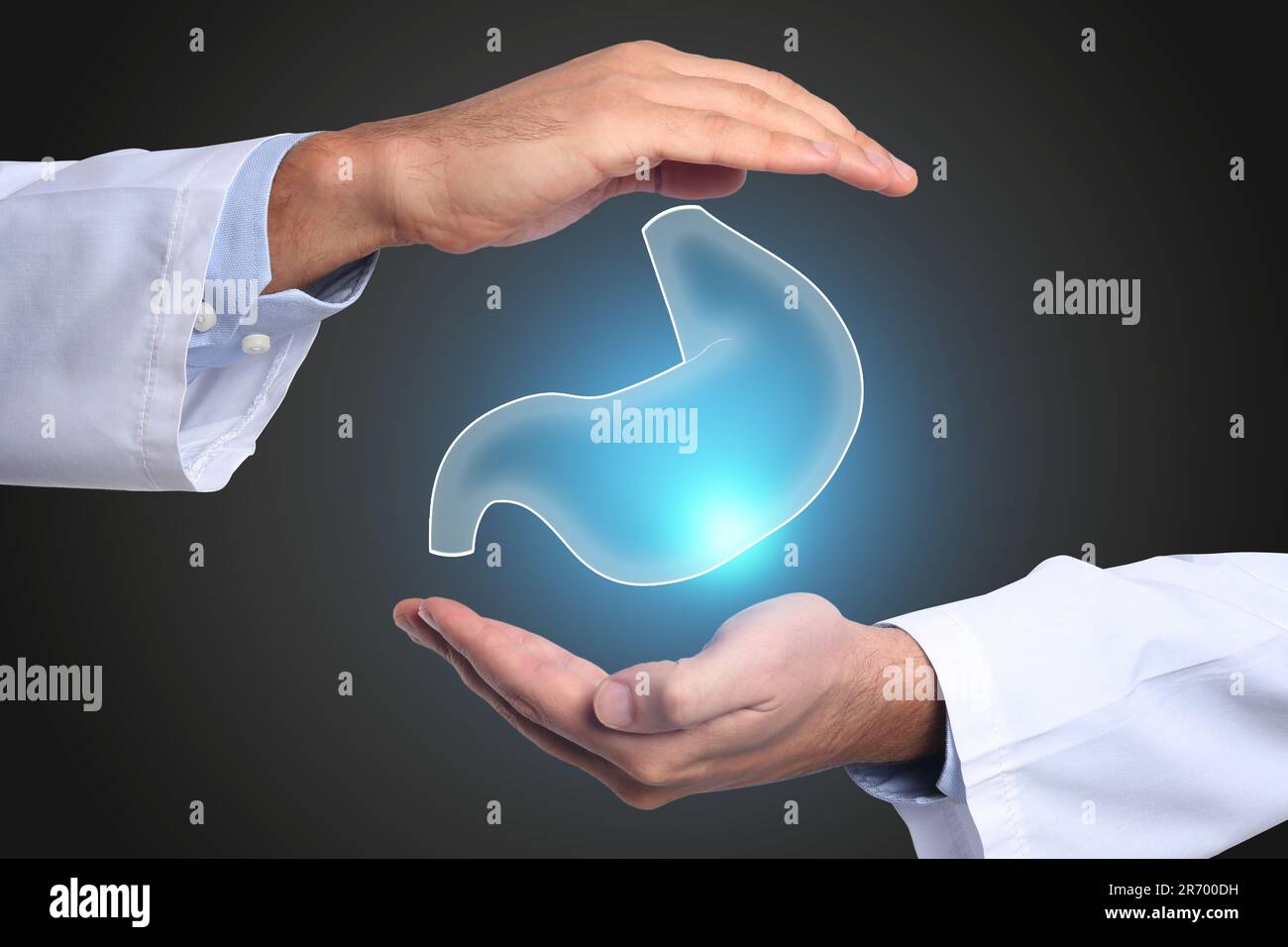 Symptoms and treatment of heartburn and other gastrointestinal diseases. Doctor holding stomach illustration on black background, closeup Stock Photo