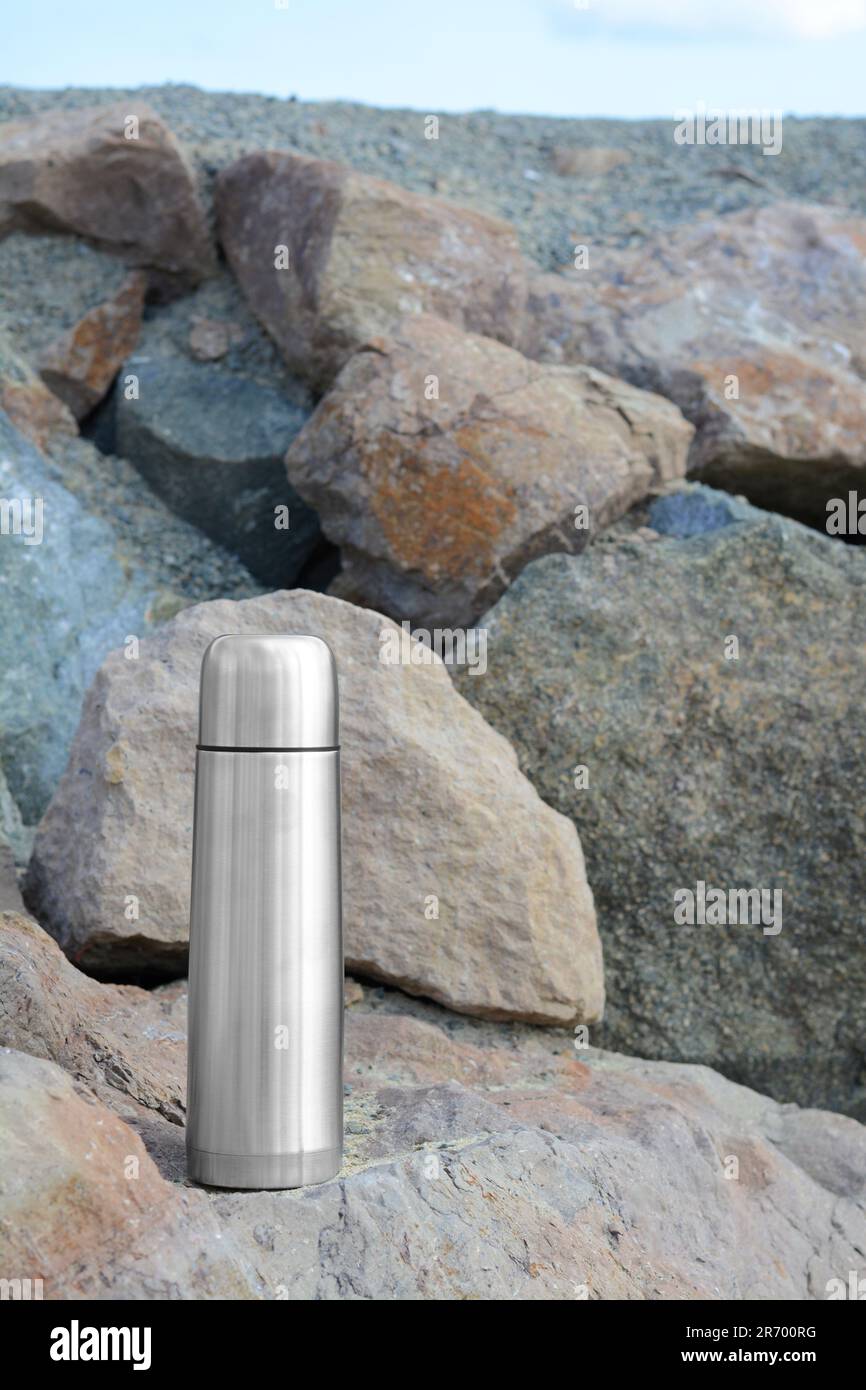 https://c8.alamy.com/comp/2R700RG/metallic-thermos-with-hot-drink-on-stone-outdoors-space-for-text-2R700RG.jpg