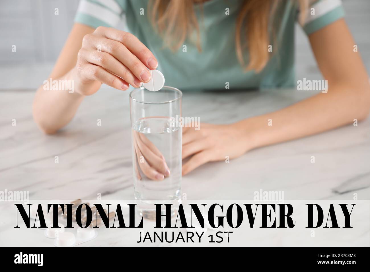National hangover day - January 1st. Woman taking remedy to relieve effects of alcohol consumption at table, closeup Stock Photo