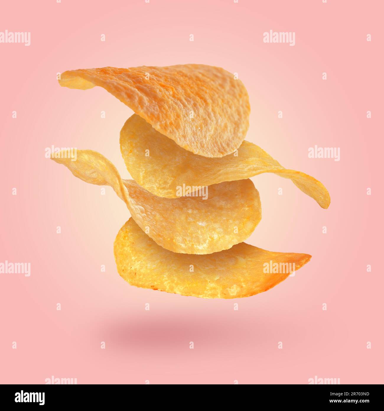 Stack of tasty potato chips falling on pink background Stock Photo Alamy