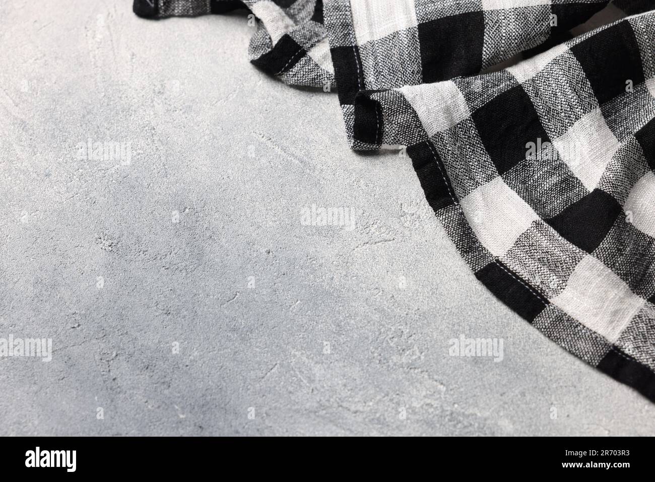 Black checkered tablecloth on light gray textured table, space for text Stock Photo
