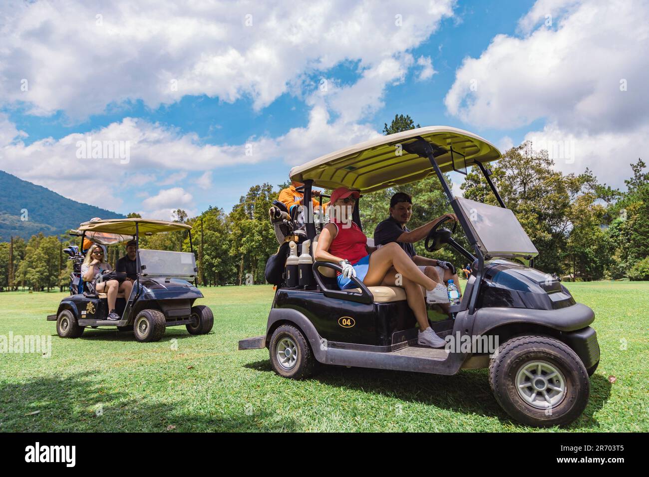 Golfers in golf carts on golf course, Bedugul, Bali, Indonesia Stock Photo