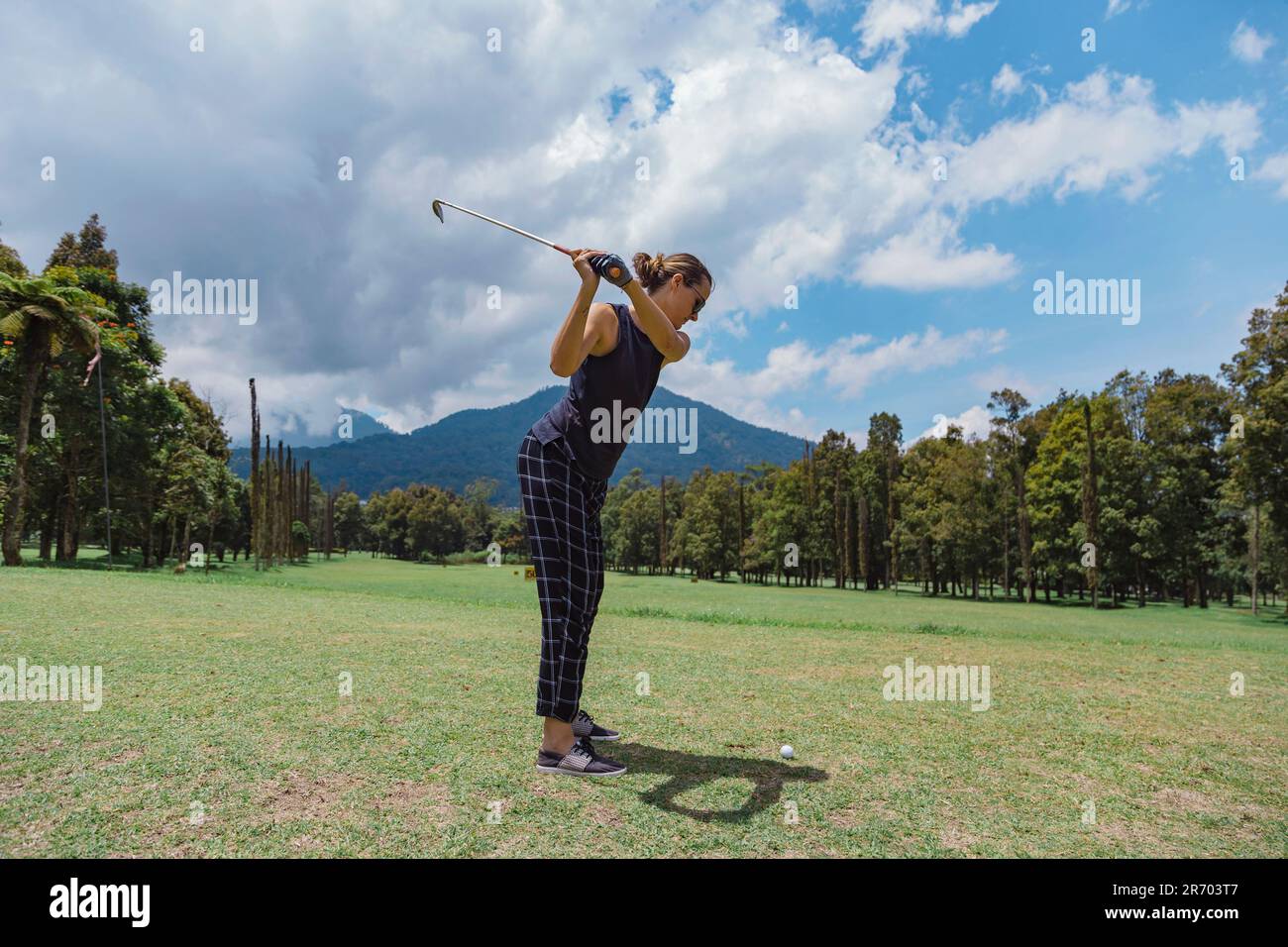 Woman swinging golf club hi-res stock photography and images - Alamy
